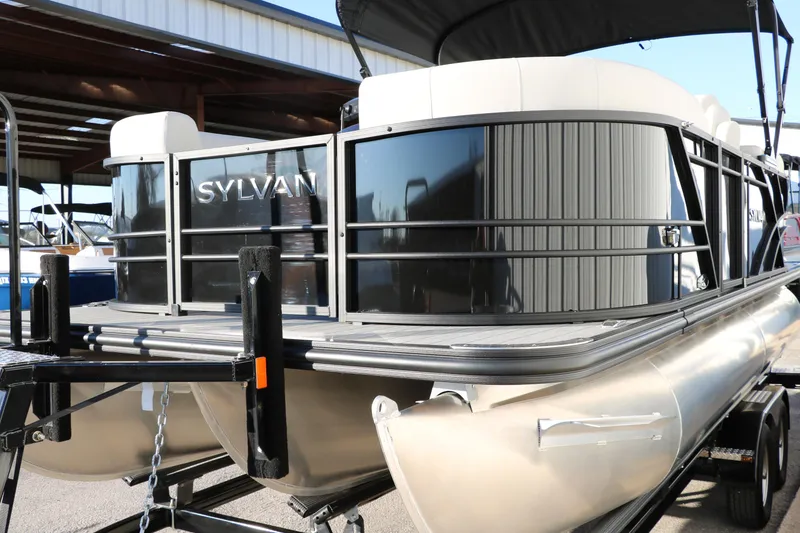 Slide: The Image of 2025 Sylvan Mirage X1 pontoon boat on trailer, showcasing sleek design and modern features. - 7