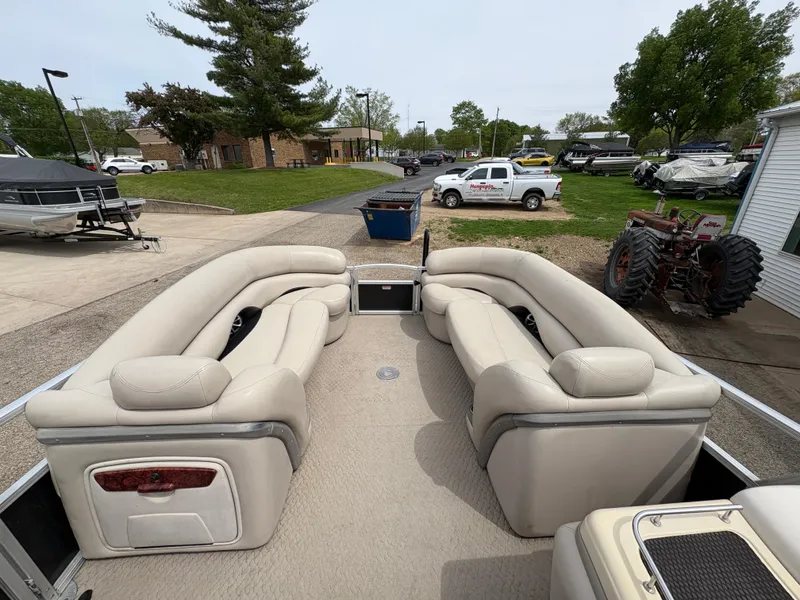 Slide: The Image of 2011 Sun Tracker PARTY BARGE 25 with spacious seating, parked outdoors. - 13