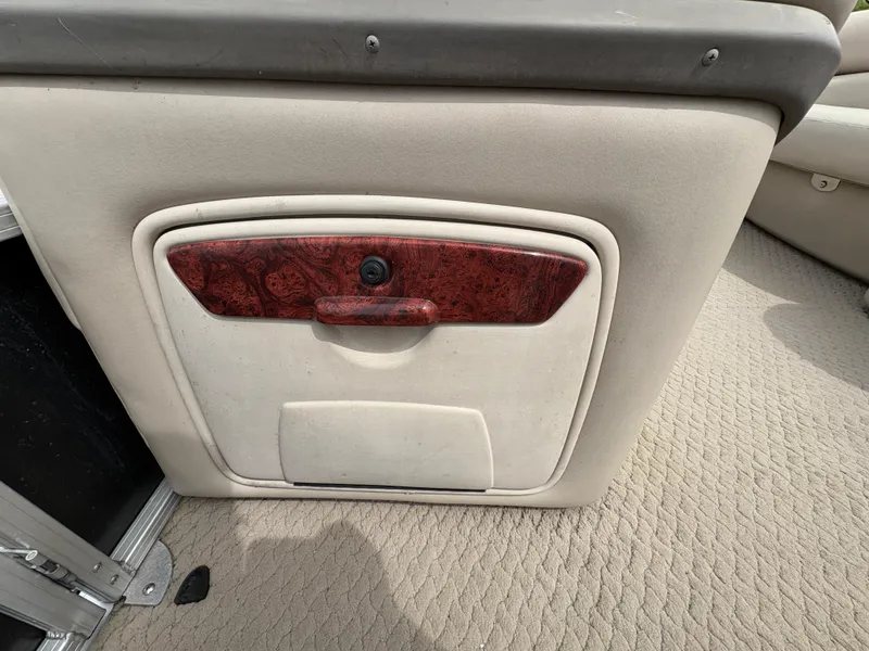 Slide: The Image of Sun Tracker PARTY BARGE 25, 2011 model, beige interior storage compartment with wood accent. - 14