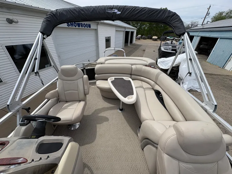 Slide: The Image of 2011 Sun Tracker PARTY BARGE 25 pontoon boat with beige seating and canopy in a showroom. - 19