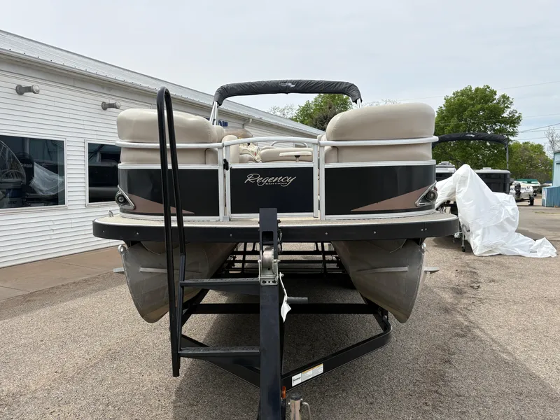 Slide: The Image of 2011 Sun Tracker PARTY BARGE 25 pontoon boat on trailer, parked outdoors. - 2