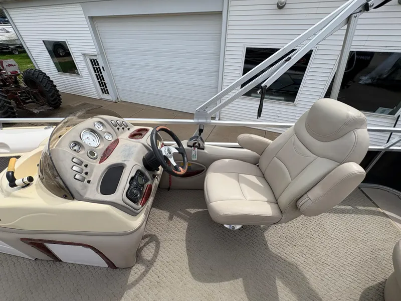 Slide: The Image of 2011 Sun Tracker PARTY BARGE 25 helm with beige captain's chair and control panel. - 20