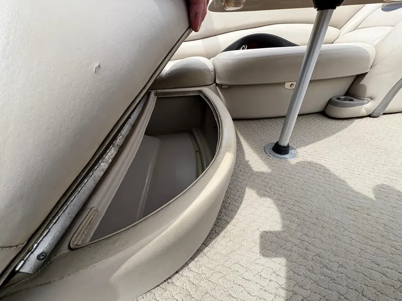 Slide: The Image of 2011 Sun Tracker PARTY BARGE 25 interior storage compartment with beige seating and carpet. - 25