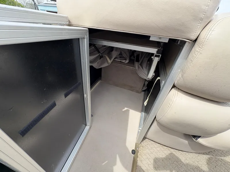 Slide: The Image of 2011 Sun Tracker PARTY BARGE 25 storage compartment with open door, revealing interior space. - 27