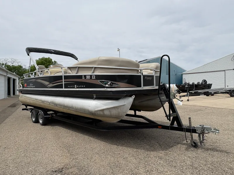 Slide: The Image of 2011 Sun Tracker PARTY BARGE 25 pontoon boat on trailer, parked outdoors. - 3