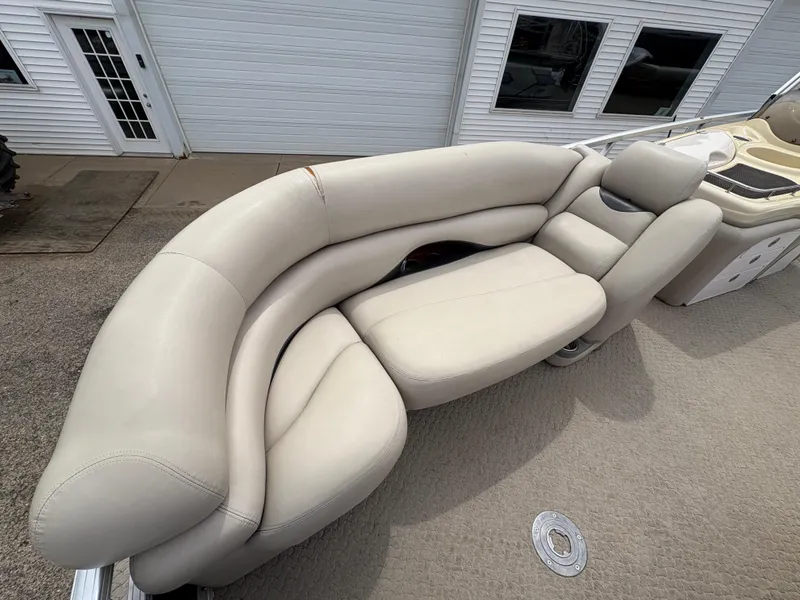 Slide: The Image of 2011 Sun Tracker PARTY BARGE 25 with beige seating, docked near a white building. - 8