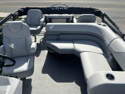Slide: The Image of 2025 Lowe SF 214 pontoon boat interior with gray seating and steering wheel. - 2