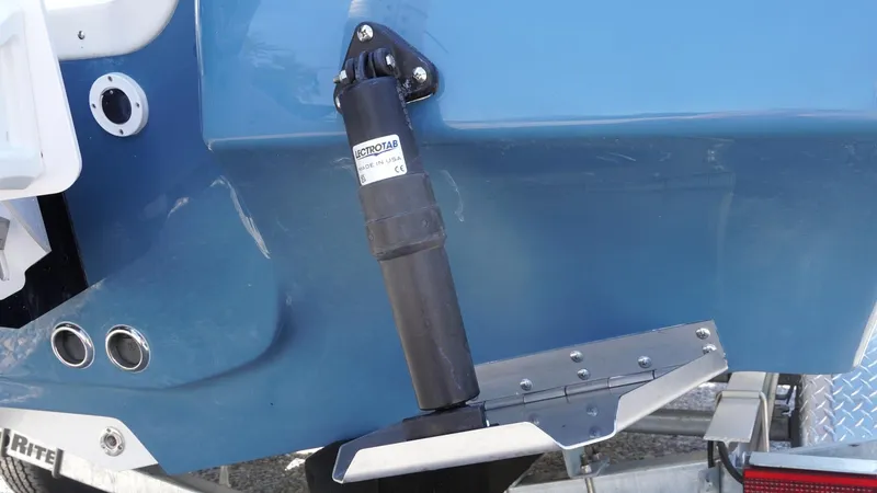 Slide: The Image of 2025 Tidewater 2300 Carolina Bay boat with a foldable swim ladder on gravel surface. - 15