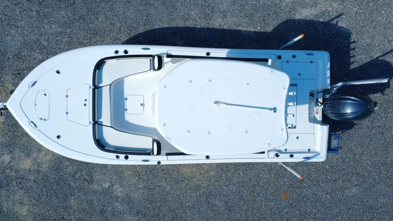 Slide: The Image of 2025 Tidewater 2300 Carolina Bay boat, front view, sleek design on gravel surface. - 3