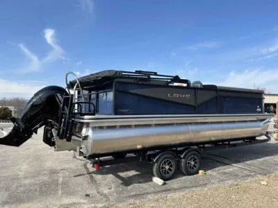 Slide: The Image of 2025 Lowe LS 230 WT pontoon boat on trailer under clear blue sky. - 4
