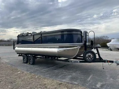 Slide: The Image of 2025 Lowe LS 210 WT pontoon boat on trailer under cloudy sky. - 1