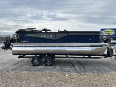 Slide: The Image of 2025 Lowe LS 210 WT pontoon boat on trailer, parked outdoors. - 3