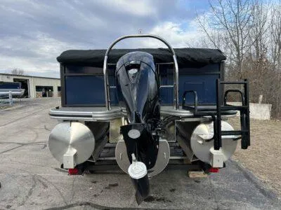 Slide: The Image of 2025 Lowe LS 210 WT pontoon boat with outboard motor, parked on a paved area. - 5