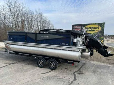 Slide: The Image of 2025 Lowe LS 210 WT pontoon boat on trailer, parked outdoors. - 6