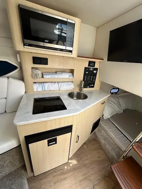 Slide: The Image of 2024 Regal 26 XO boat interior with kitchenette, microwave, sleeping area. - 7