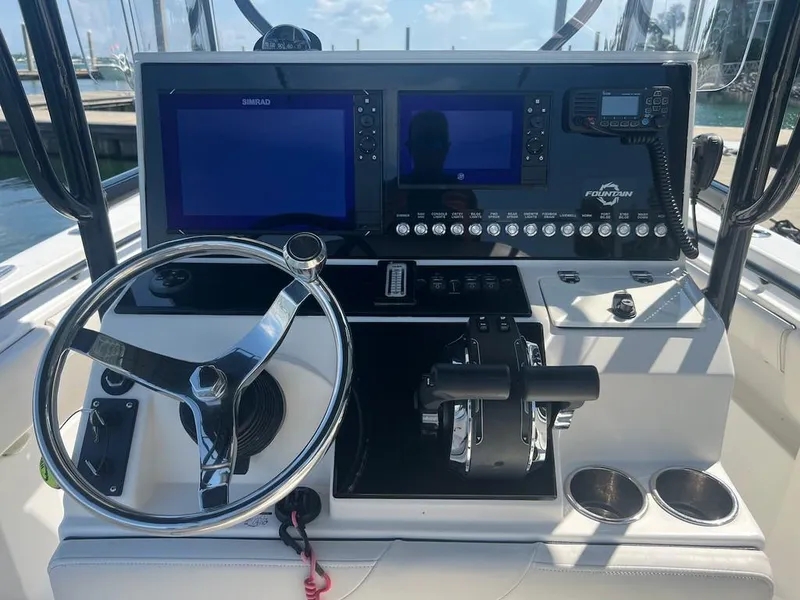 Slide: The Image of 2006 Fountain 23 Tournament CC boat dashboard with steering wheel and electronic controls. - 3