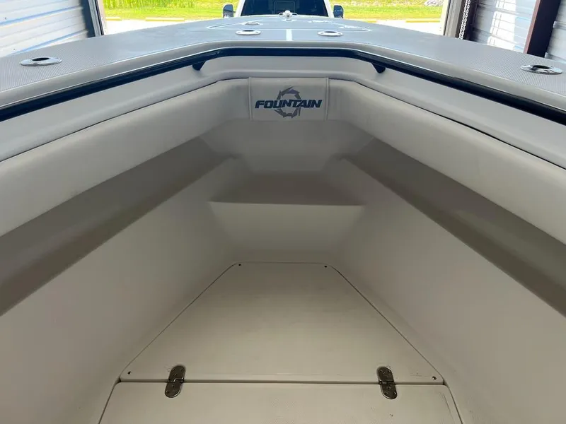 Slide: The Image of 2006 Fountain 23 Tournament CC boat interior with white seating and storage compartment. - 8