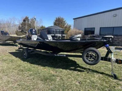 Slide: The Image of 2025 Lowe Stinger 195 Bass boat on trailer, parked outdoors near a building. - 5