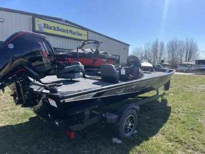 Slide: The Image of 2025 Lowe Stinger 195 Bass boat at BlackBeard Marine dealership, parked on grass. - 6
