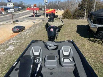 Slide: The Image of 2025 Lowe Stinger 195 Bass boat on display near a roadside, featuring dual seats. - 7