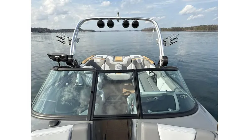 Slide: The Image of 2023 MasterCraft XT22 boat on calm lake with clear sky and modern design. - 10