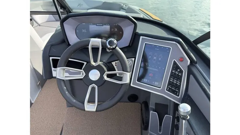Slide: The Image of 2023 MasterCraft XT22 boat dashboard with steering wheel and touchscreen controls. - 6