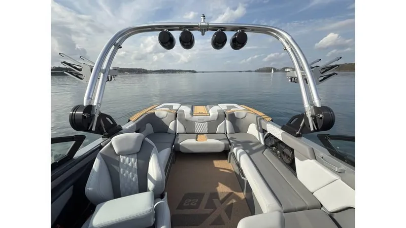 Slide: The Image of 2023 MasterCraft XT22 boat interior with luxury seating and lake view. - 9