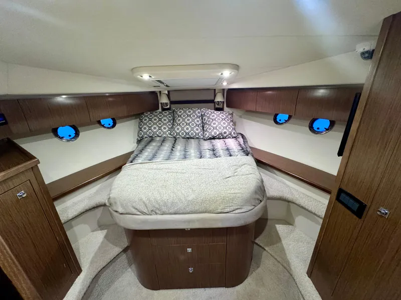 Slide: The Image of Luxurious cabin interior of 2014 Cruisers Yachts 54 Sport Coupe with cozy bed and elegant wood finish. - 25