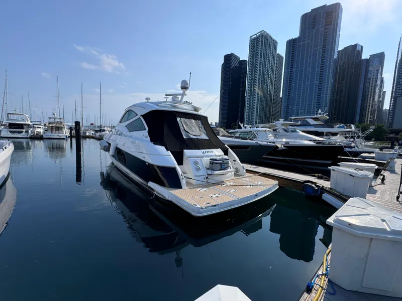 Slide: The Image of 2014 Cruisers Yachts 54 Sport Coupe docked in a marina with city skyline. - 3