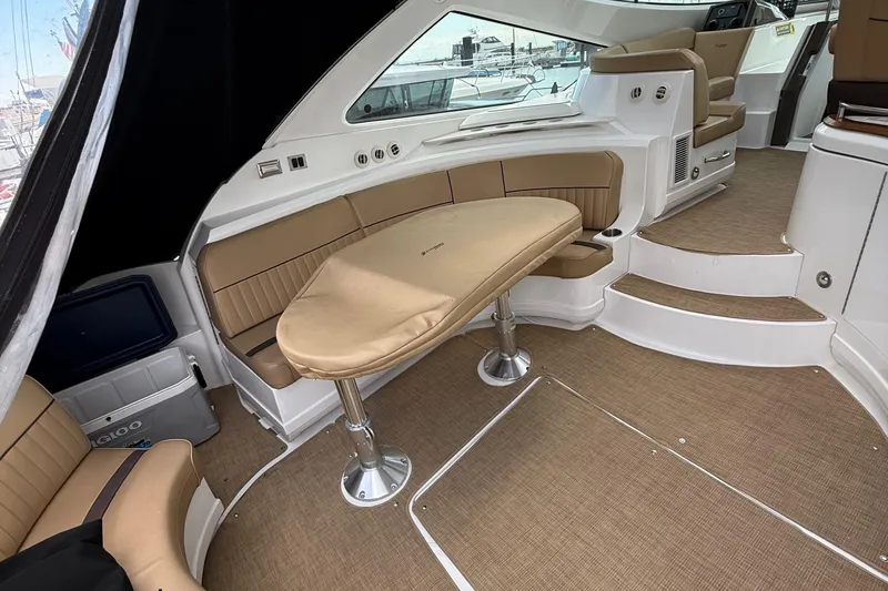 Slide: The Image of Interior of 2014 Cruisers Yachts 54 Sport Coupe with tan seating and table. - 60