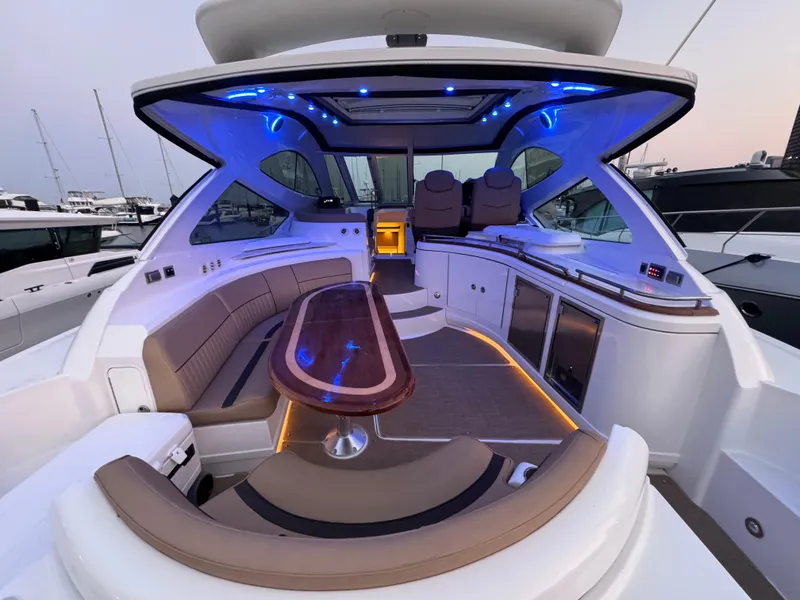 Slide: The Image of Luxurious 2014 Cruisers Yachts 54 Sport Coupe interior with ambient blue lighting and elegant seating. - 17