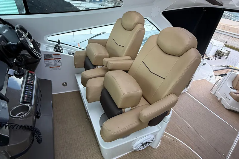 Slide: The Image of Luxurious helm seating on 2014 Cruisers Yachts 54 Sport Coupe, featuring dual beige captain chairs. - 37