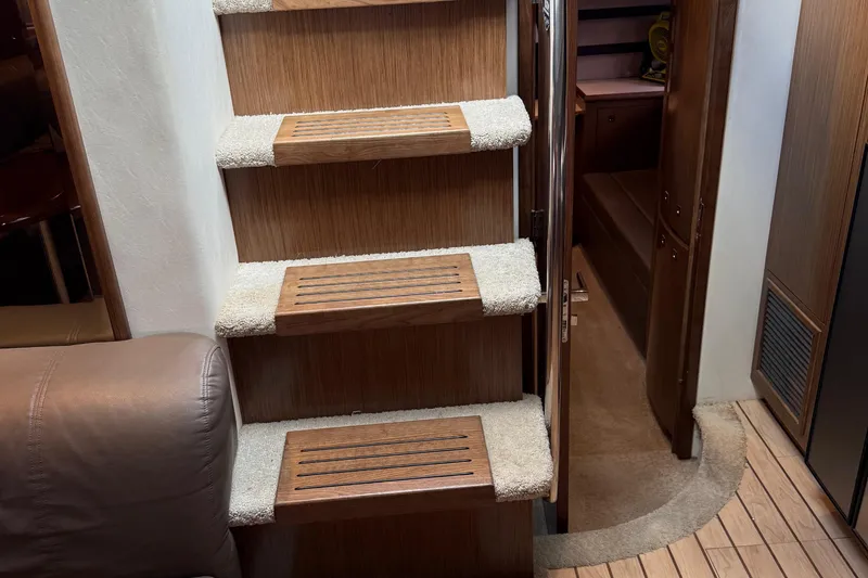 Slide: The Image of Interior stairs of 2014 Cruisers Yachts 54 Sport Coupe, featuring wooden steps and carpet accents. - 41