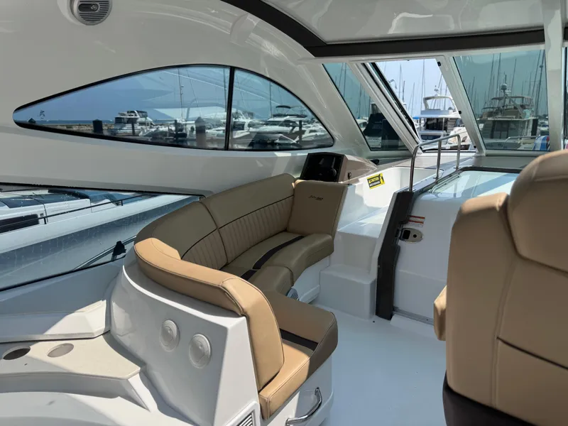 Slide: The Image of 2014 Cruisers Yachts 54 Sport Coupe interior with beige seating and large windows. - 7