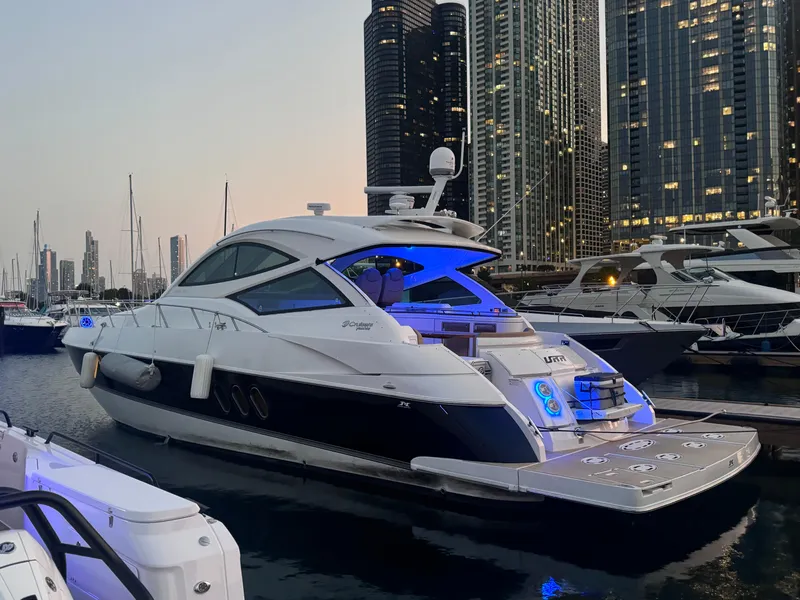 Slide: The Image of 2014 Cruisers Yachts 54 Sport Coupe docked in a marina with city skyline backdrop. - 8