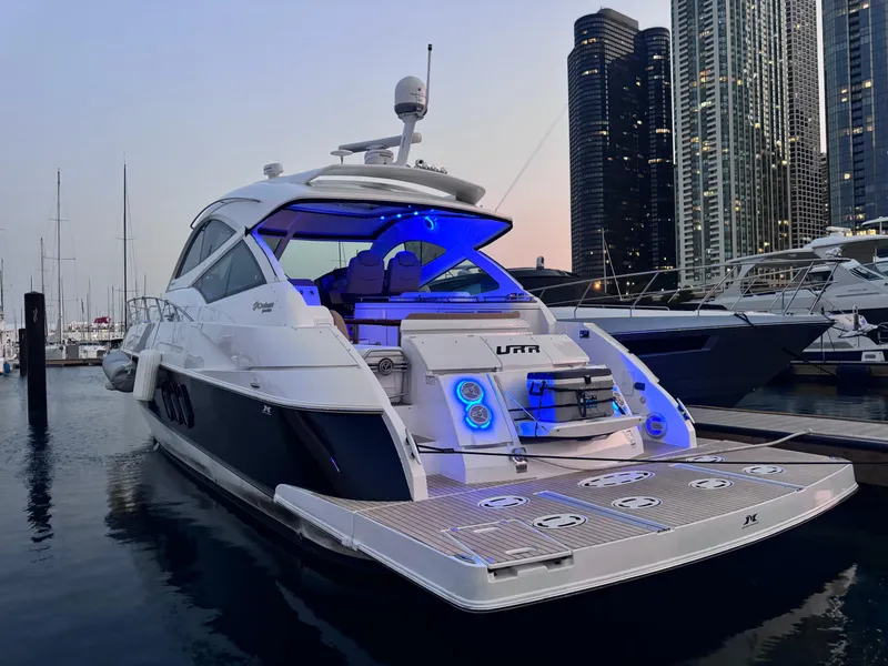 Slide: The Image of 2014 Cruisers Yachts 54 Sport Coupe docked at marina, illuminated with blue lights. - 9