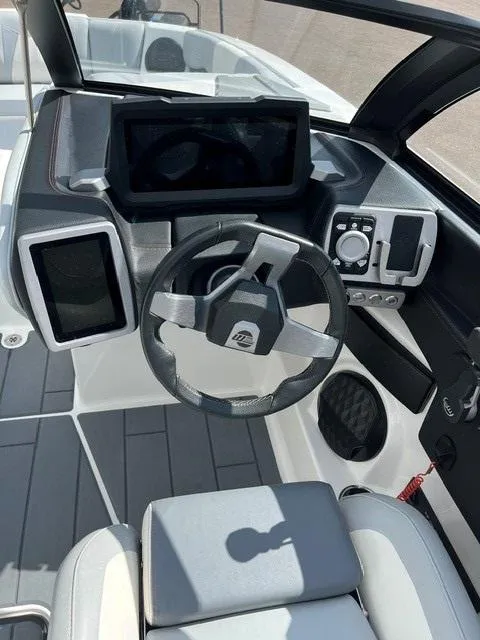 Slide: The Image of 2023 Malibu Wakesetter 24 MXZ dashboard with modern steering and control panel. - 11