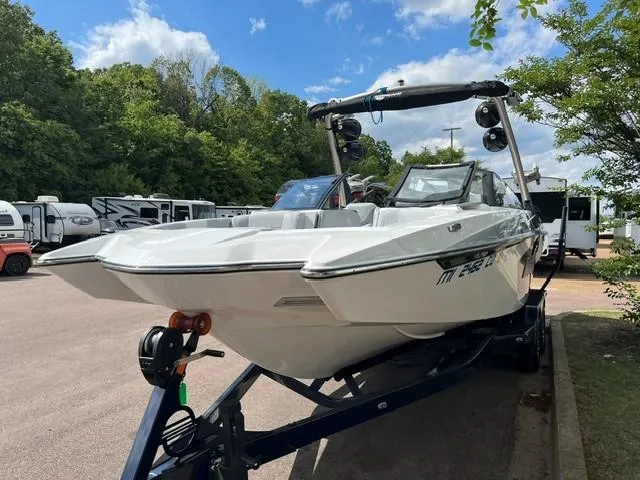 Slide: The Image of 2023 Malibu Wakesetter 24 MXZ boat on trailer, parked outdoors. - 2