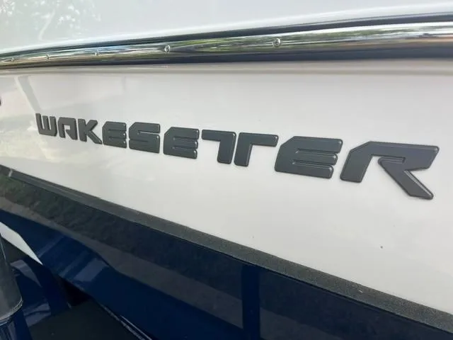 Slide: The Image of 2023 Malibu Wakesetter 24 MXZ boat logo on white hull. - 6