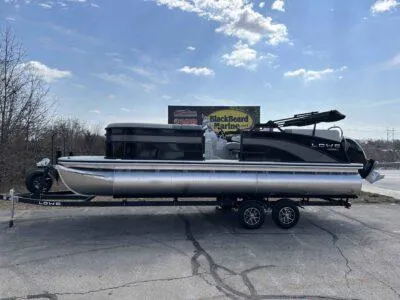 Slide: The Image of 2025 Lowe SS 230 WT pontoon boat on trailer under a clear sky. - 1