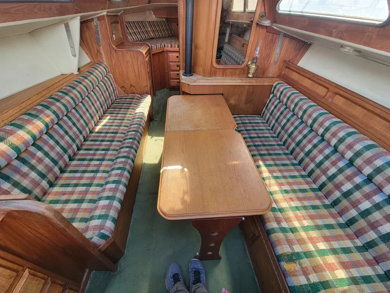 Slide: The Image of 1977 Islander 27 yacht interior with striped upholstery and wooden table. - 15