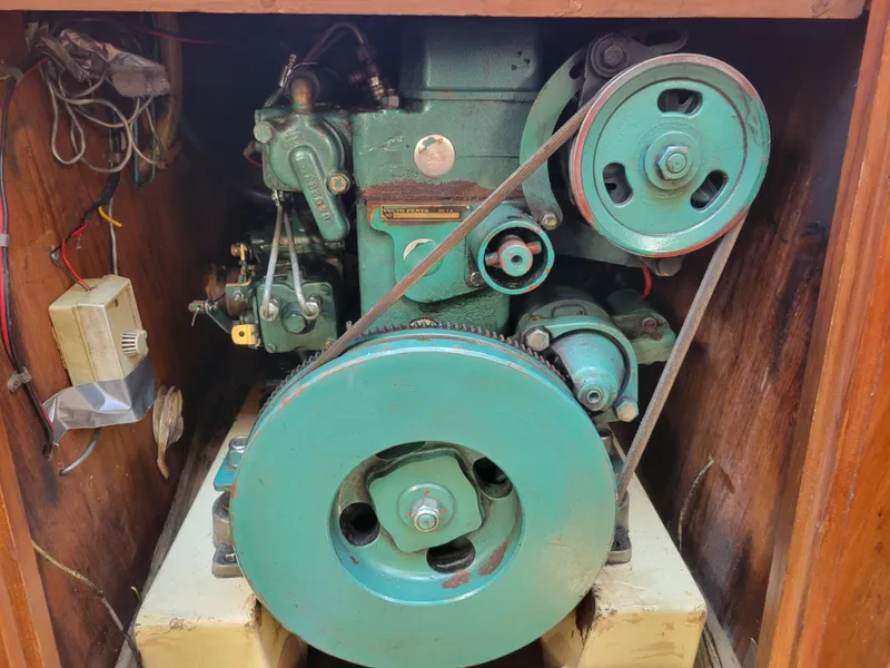 Slide: The Image of 1977 Islander 27 engine compartment with visible green machinery and wiring. - 19