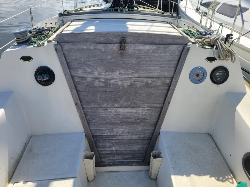Slide: The Image of 1977 Islander 27 sailboat cockpit with wooden hatch and nautical equipment. - 7