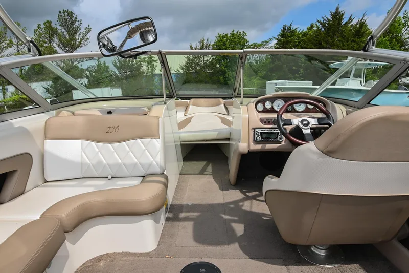 Slide: The Image of 2001 MasterCraft MariStar 230 boat interior with beige and white seating, steering wheel, and dashboard. - 15