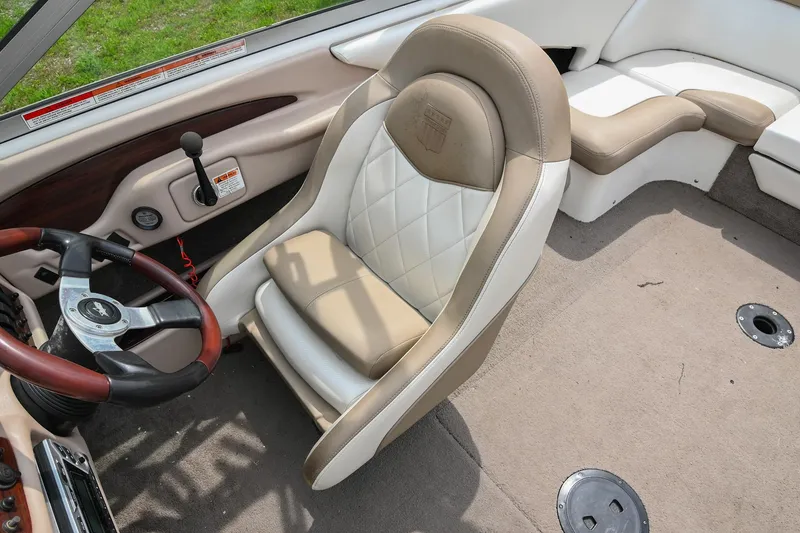 Slide: The Image of 2001 MasterCraft MariStar 230 boat interior with beige seating and steering wheel. - 20