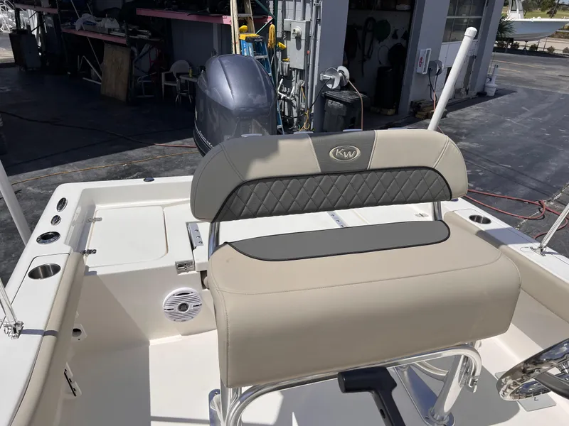 Slide: The Image of 2025 Key West 179 FS boat interior with cushioned seating and motor in a marina setting. - 5