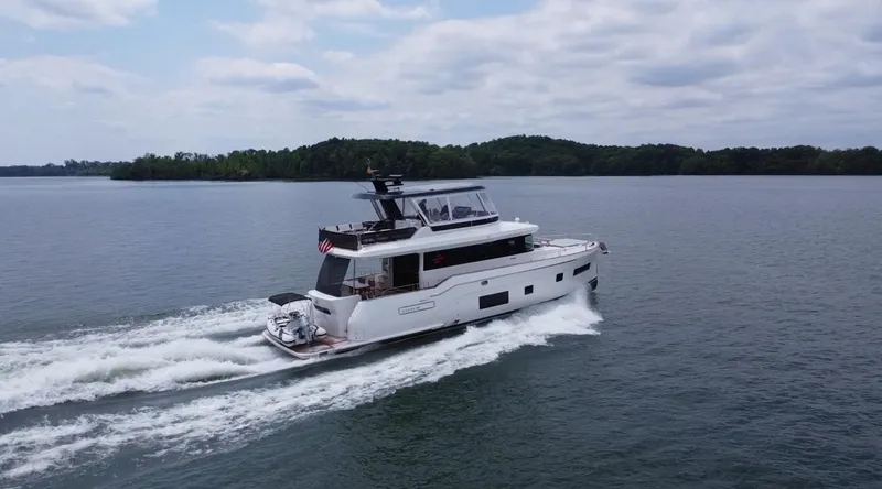 Slide: The Image of 2021 Sirena 58 yacht cruising on a calm lake under a cloudy sky. - 10