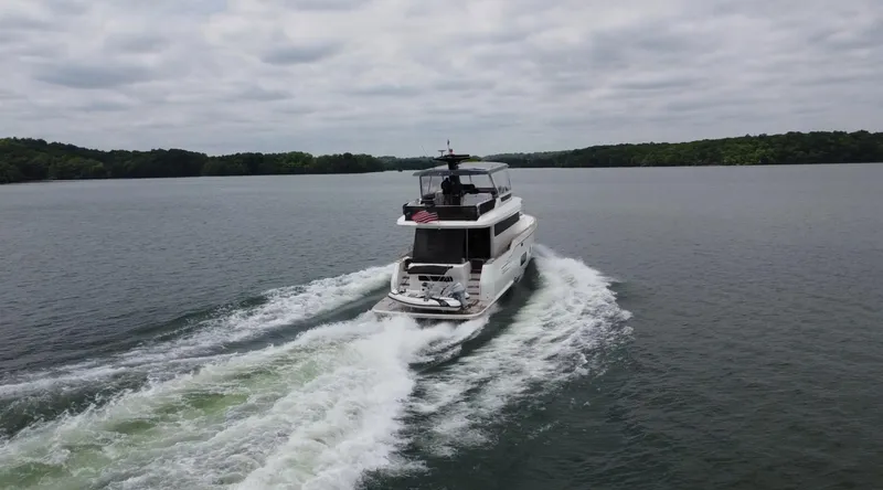 Slide: The Image of Sirena 58 yacht cruising on a lake, 2021 model, surrounded by lush greenery. - 15