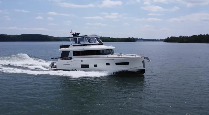 Slide: The Image of 2021 Sirena 58 yacht cruising on a calm lake under a partly cloudy sky. - 3