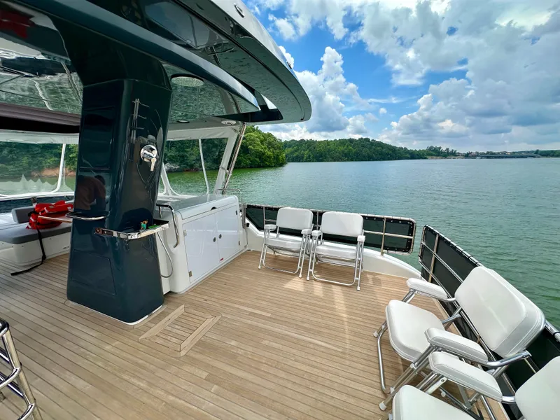 Slide: The Image of Luxury Sirena 58 yacht deck with seating, overlooking serene lake and lush greenery. - 33
